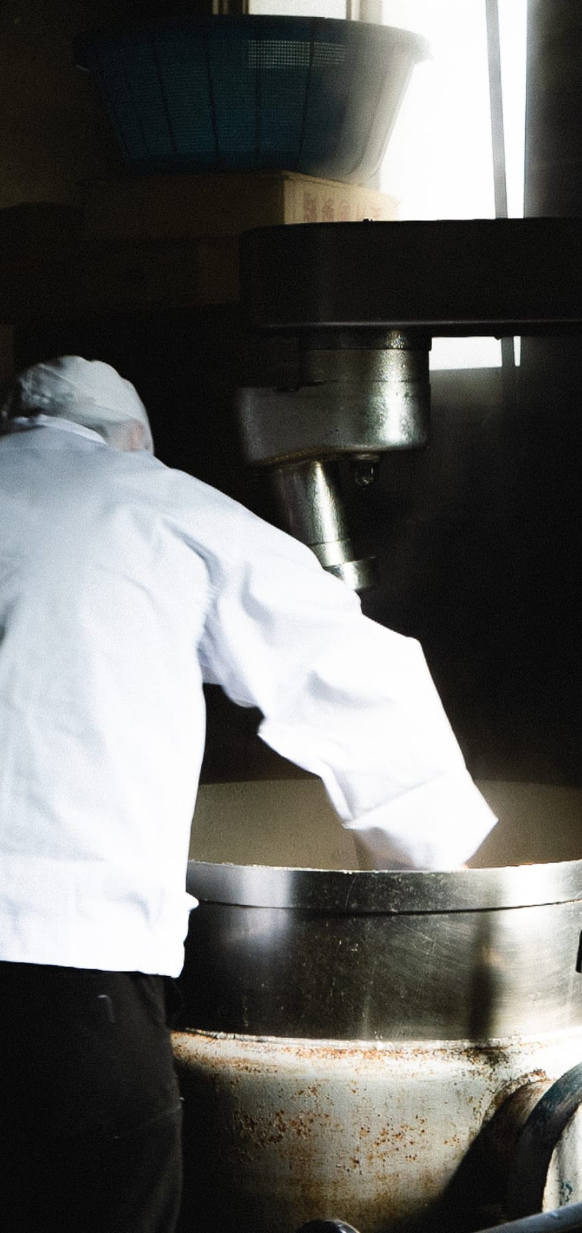 鍋の中のあんこを混ぜる職人の背中